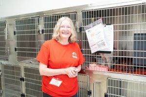 A volunteer wearing a red shirt, smiling at the camera