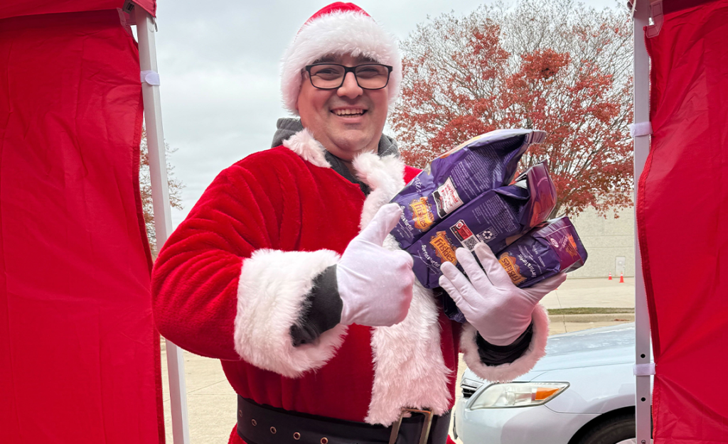 Person dressed as Santa holding pet food