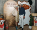 Two people standing in front of a western themed backdrop at Hope, Hearts & Boots